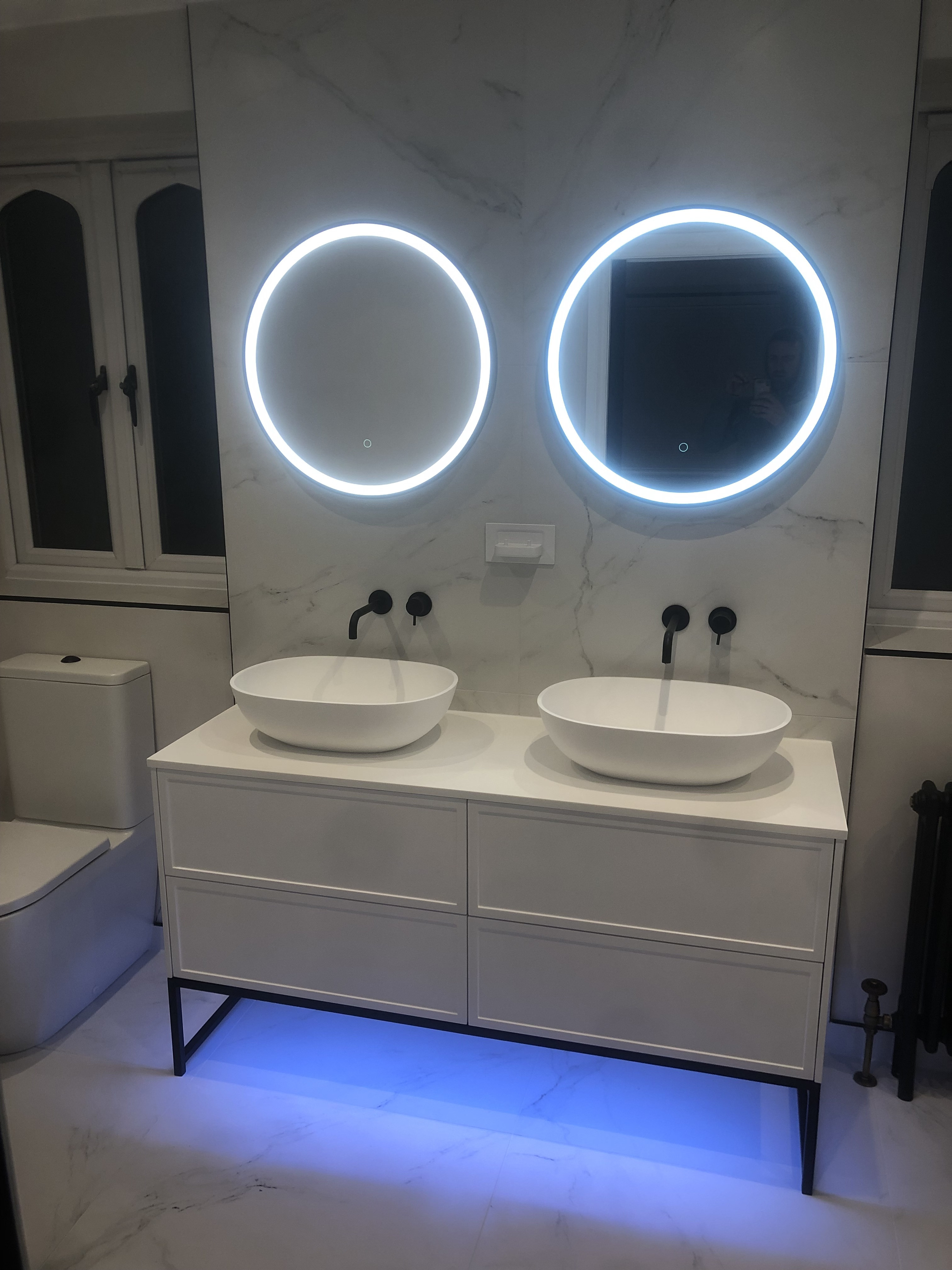 Double basin vanity with backlit mirrors and designer radiator